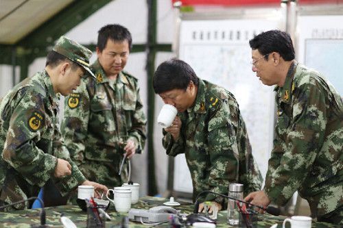 武警云南總隊司令員王誠在抗震指揮部嘗通過“凈易單兵凈水器”過濾后的水質